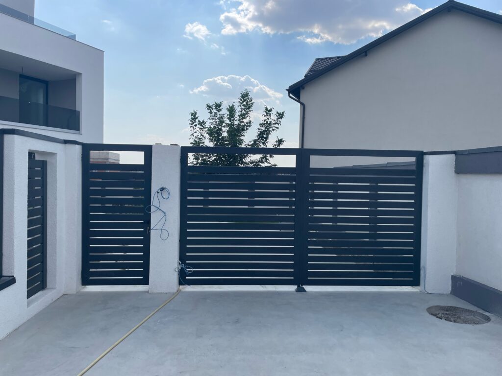 Poartă batantă cu acces pietonal, lamele orizontale antracit, casă modernă