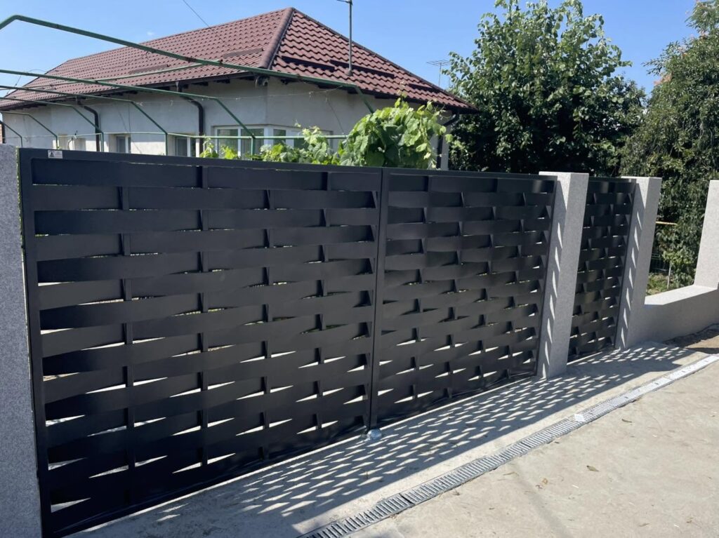 Poartă batantă modernă model împletit realizată de Fier Forjat & Inox Slătioara
Poartă metalică batantă vopsită în câmp electrostatic
Poartă metalică modernă cu model împletit